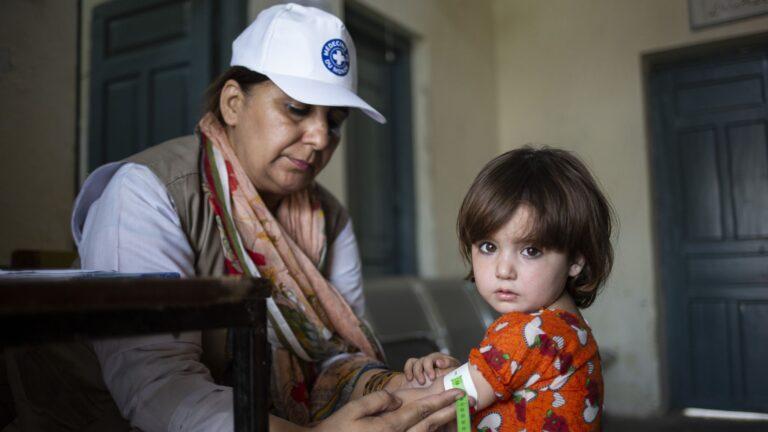 Santé des femmes et des enfants au Pakistan - staff Médecins du Monde et petite fille, test malnutrition - paysage