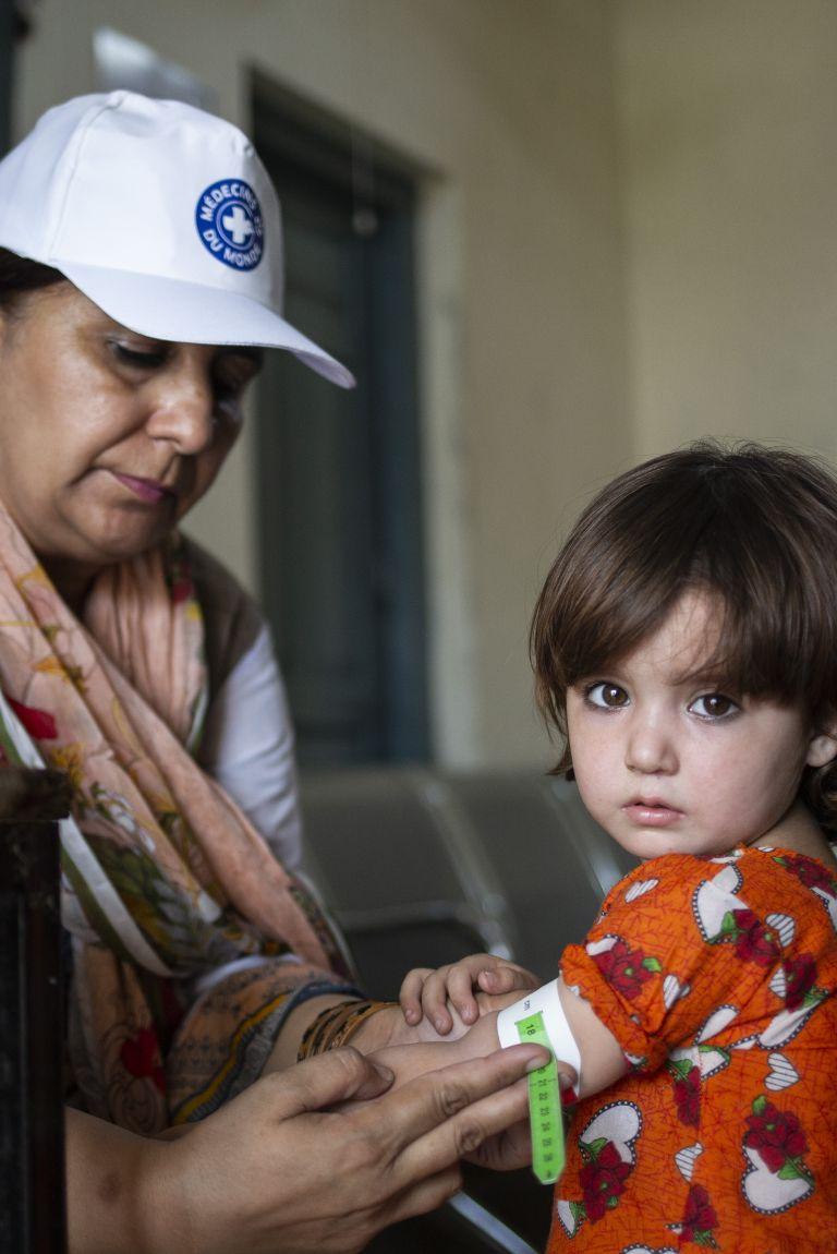 Santé des femmes et des enfants au Pakistan - staff Médecins du Monde et petite fille, test malnutrition